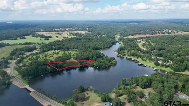 an aerial view of a house with a yard lake view and mountain view in back