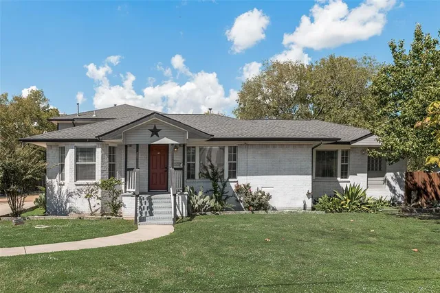 a front view of a house with a garden and yard