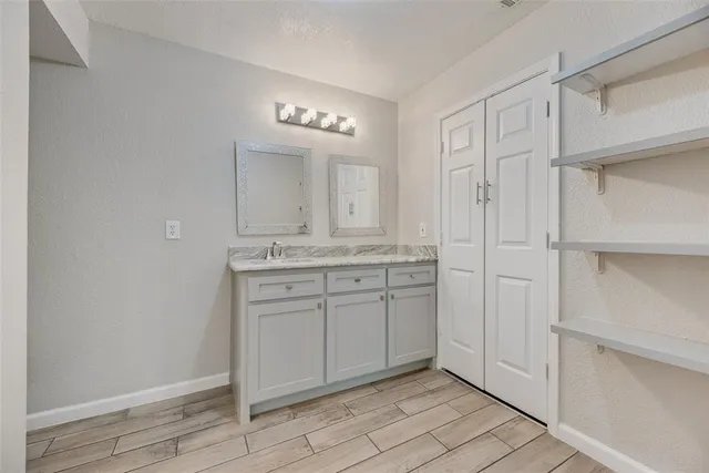 a spacious bathroom with a granite countertop sink and a mirror