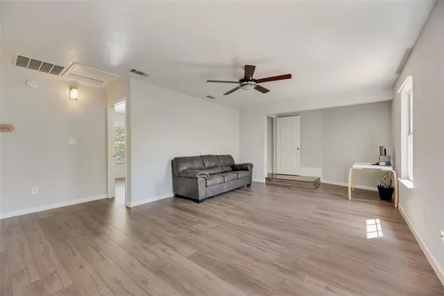 a living room with furniture and a ceiling fan