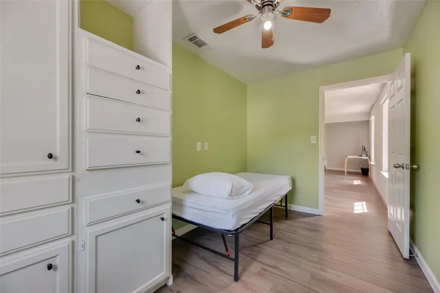 a view of a room with cabinet cabinet mirror and a wooden floor