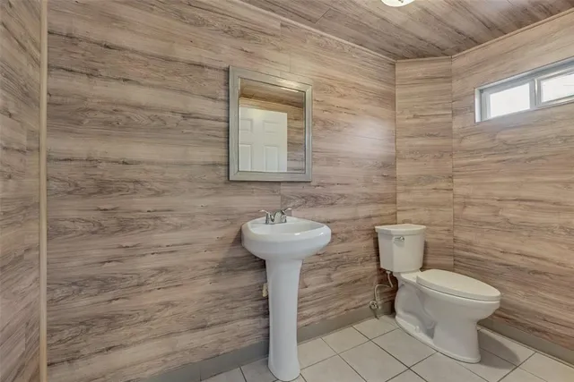a bathroom with a toilet a sink and a mirror