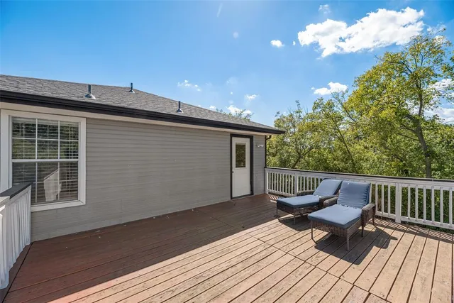 a roof deck with wooden floor and fence