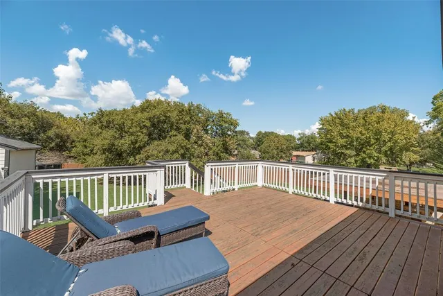a roof deck with wooden floor and fence