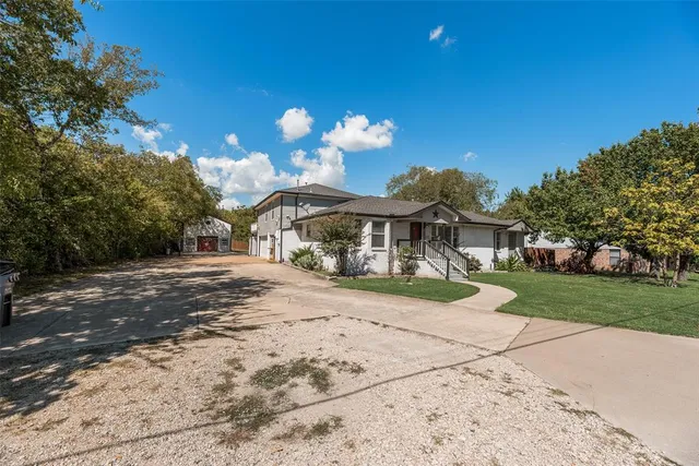 a front view of a house with a yard and potted plants