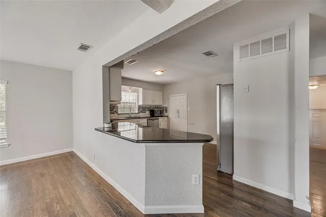 a kitchen with stainless steel appliances granite countertop a sink and a refrigerator