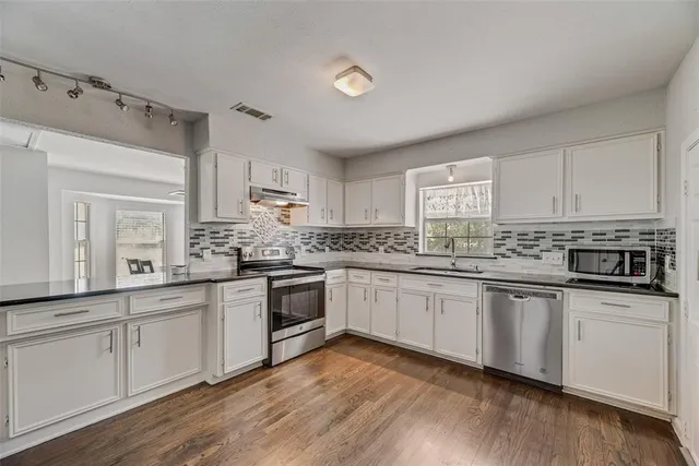 a kitchen with granite countertop white cabinets and white appliances