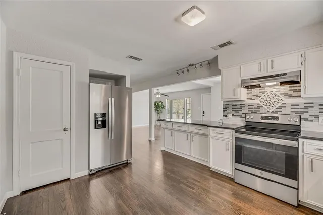 a kitchen with stainless steel appliances granite countertop a stove and a refrigerator
