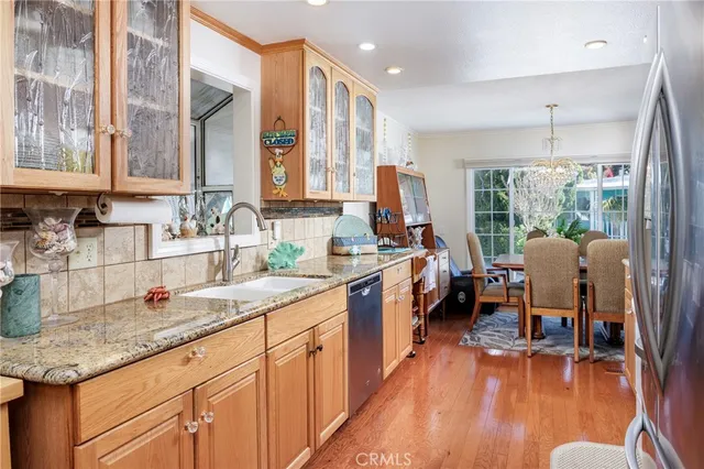 a kitchen with stainless steel appliances granite countertop sink stove and wooden floor