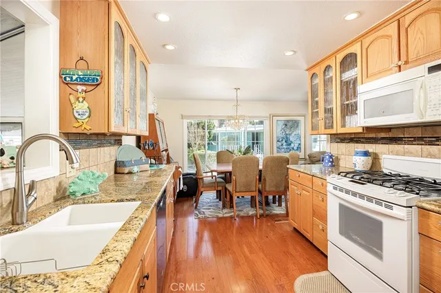 a view of a kitchen with kitchen island a large window cabinets a sink and stainless steel appliances