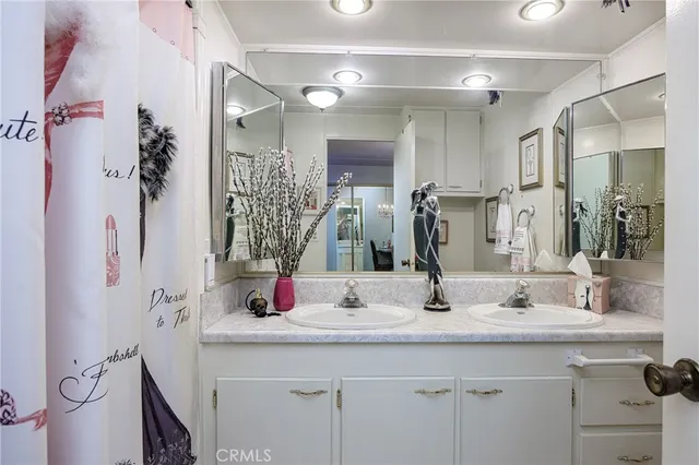 a bathroom with a double vanity sink a mirror and shower