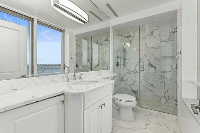 a bathroom with a sink a toilet and shower