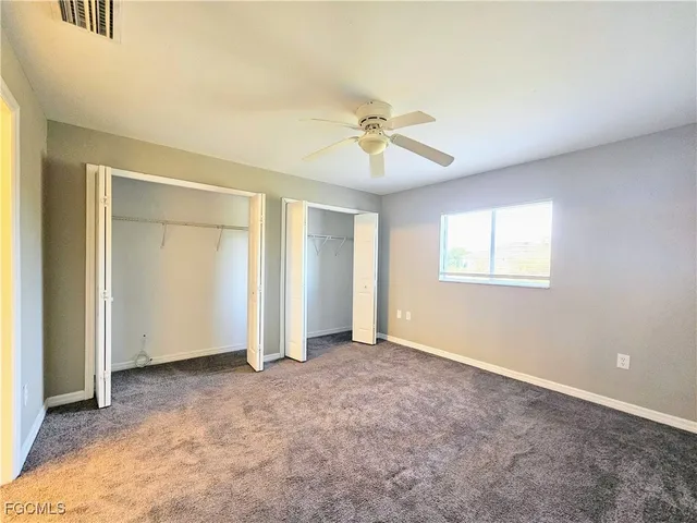 an empty room with fan and windows