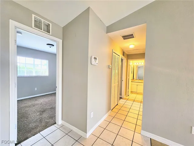 a view of a hallway with bathroom and wooden floor