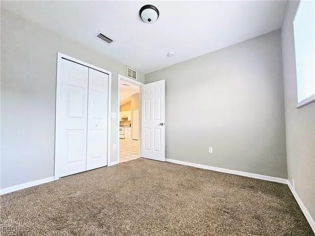 an empty room with window and closet