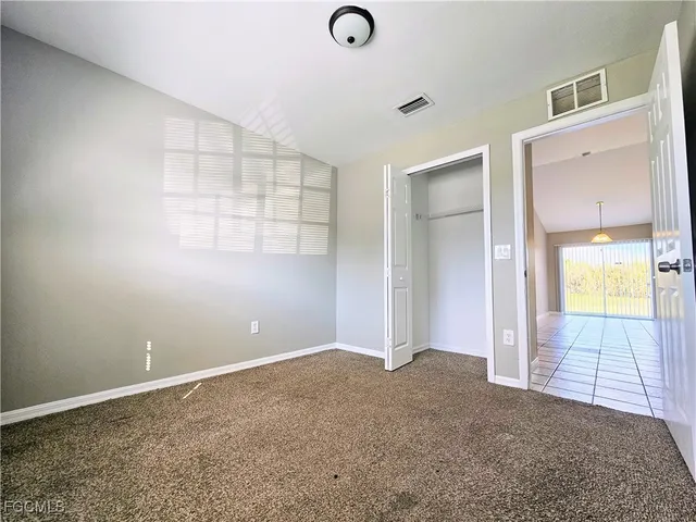 an empty room with windows and closet