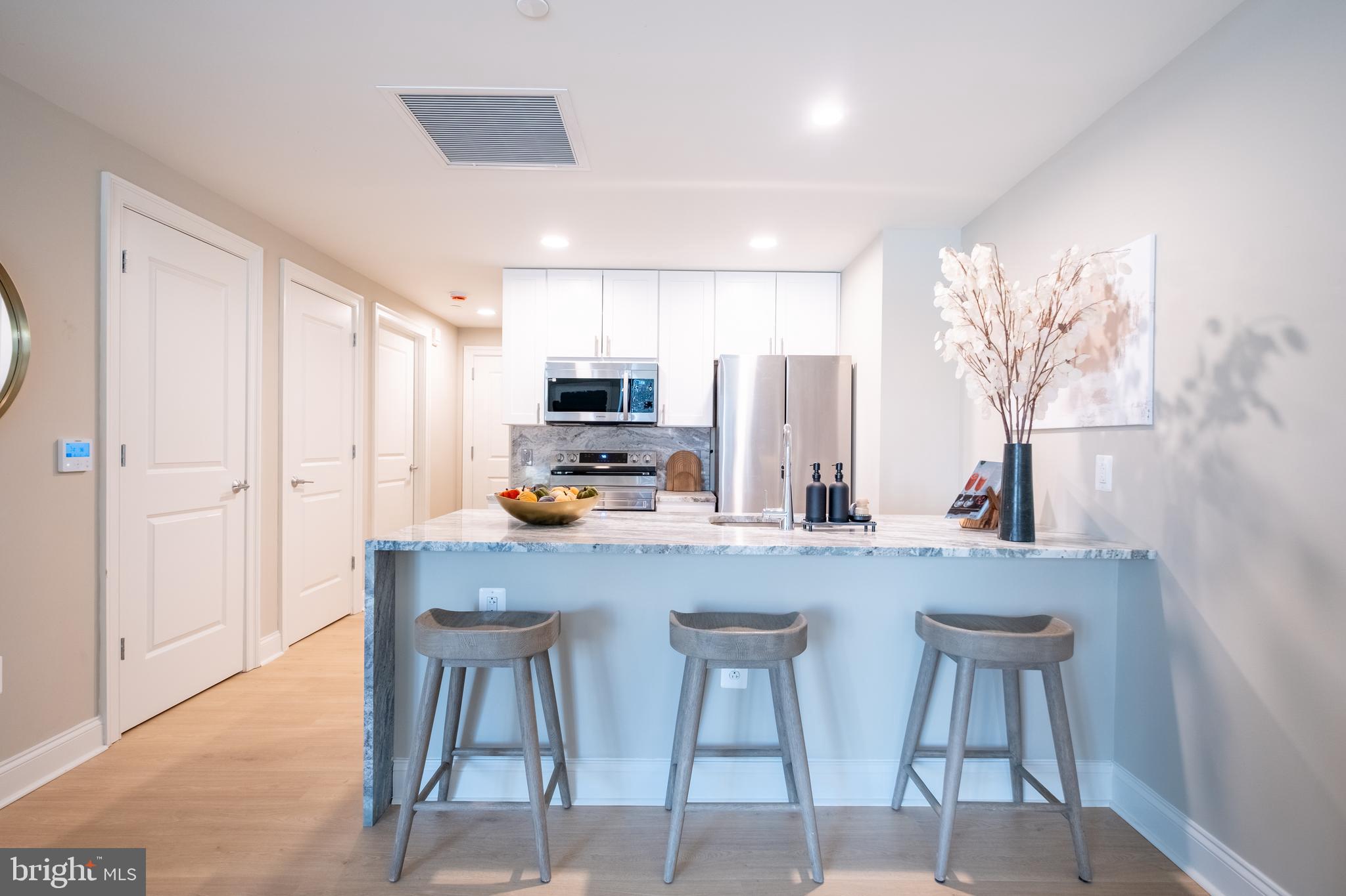 2301-61 John F Kennedy Boulevard, Unit 105 Philadelphia, PA 19103 - Photo 4 of 42 a kitchen with stainless steel appliances a table and chairs in it