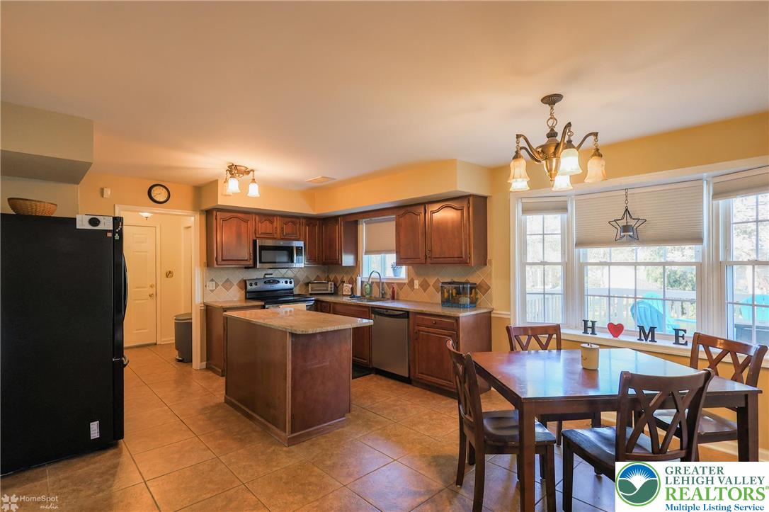 3657 Gramercy Place Bethlehem, PA 18020 - Photo 17 of 86 a kitchen with stainless steel appliances kitchen island granite countertop a table chairs and a refrigerator