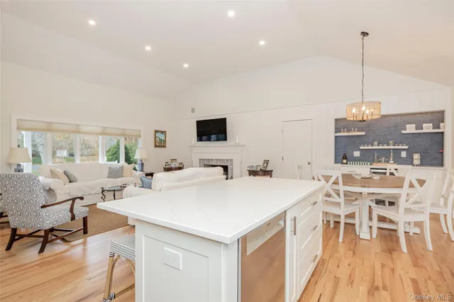 a view of a dining room with furniture a chandelier and wooden floor
