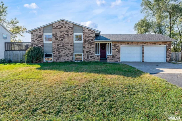 a view of a house with a yard and garage