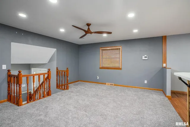 a view of an empty room with windows & cabinet