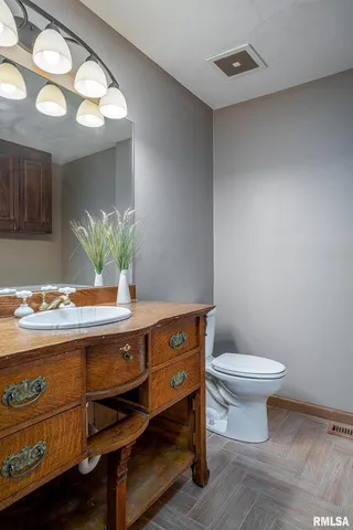 a bathroom with a sink a toilet and a mirror