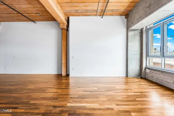 a view of a room with wooden floor and a window