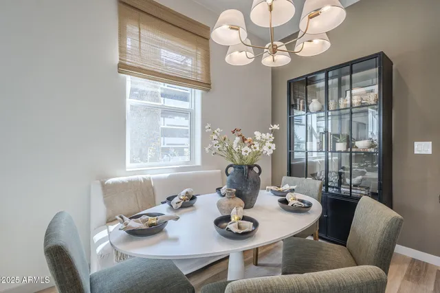 a view of a dining room with furniture a chandelier and large windows