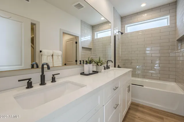 a bathroom with a double vanity sink mirror double and bathtub