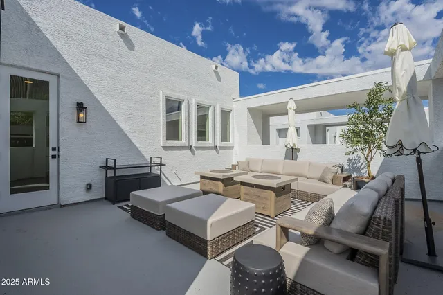 a patio with patio a couch and potted plants