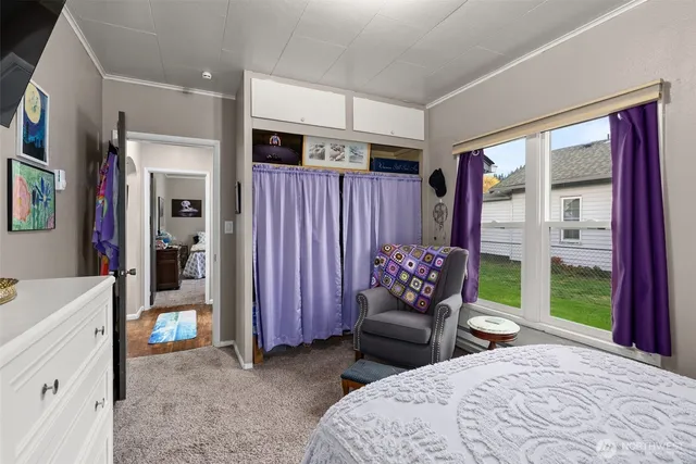 a bedroom with furniture and a large window