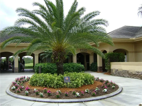 a front view of a house with a yard and potted plants