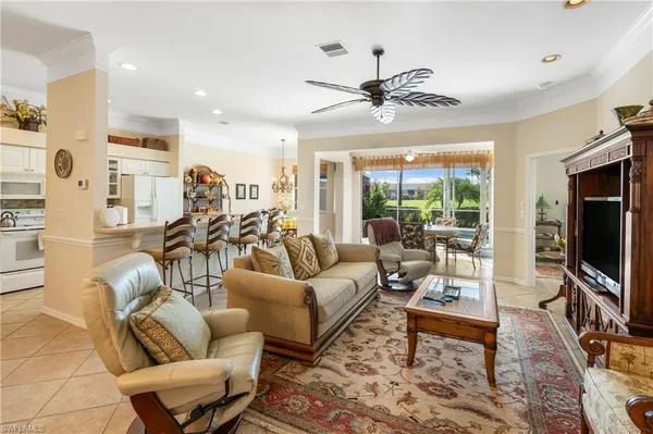 a living room with furniture a ceiling fan and a flat screen tv