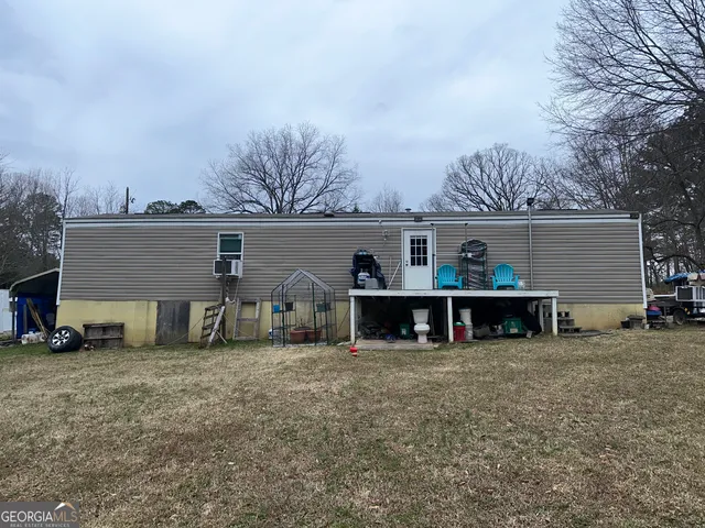 a view of a house with a big yard and a large tree