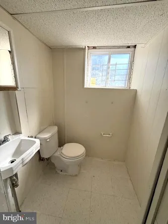 a white toilet sitting next to a bathroom sink and a window