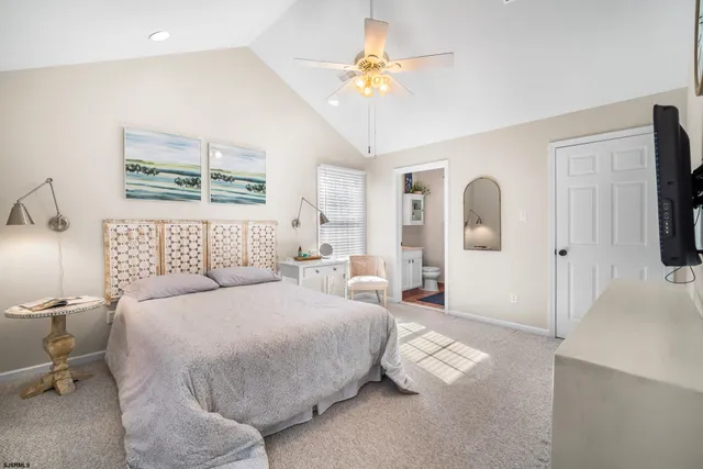 a spacious bedroom with a bed and a flat screen tv