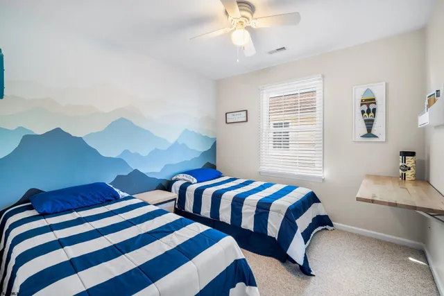 a bedroom with two beds and a desk