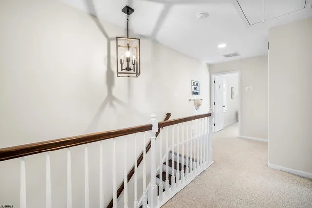 a view of staircase with railing and white walls