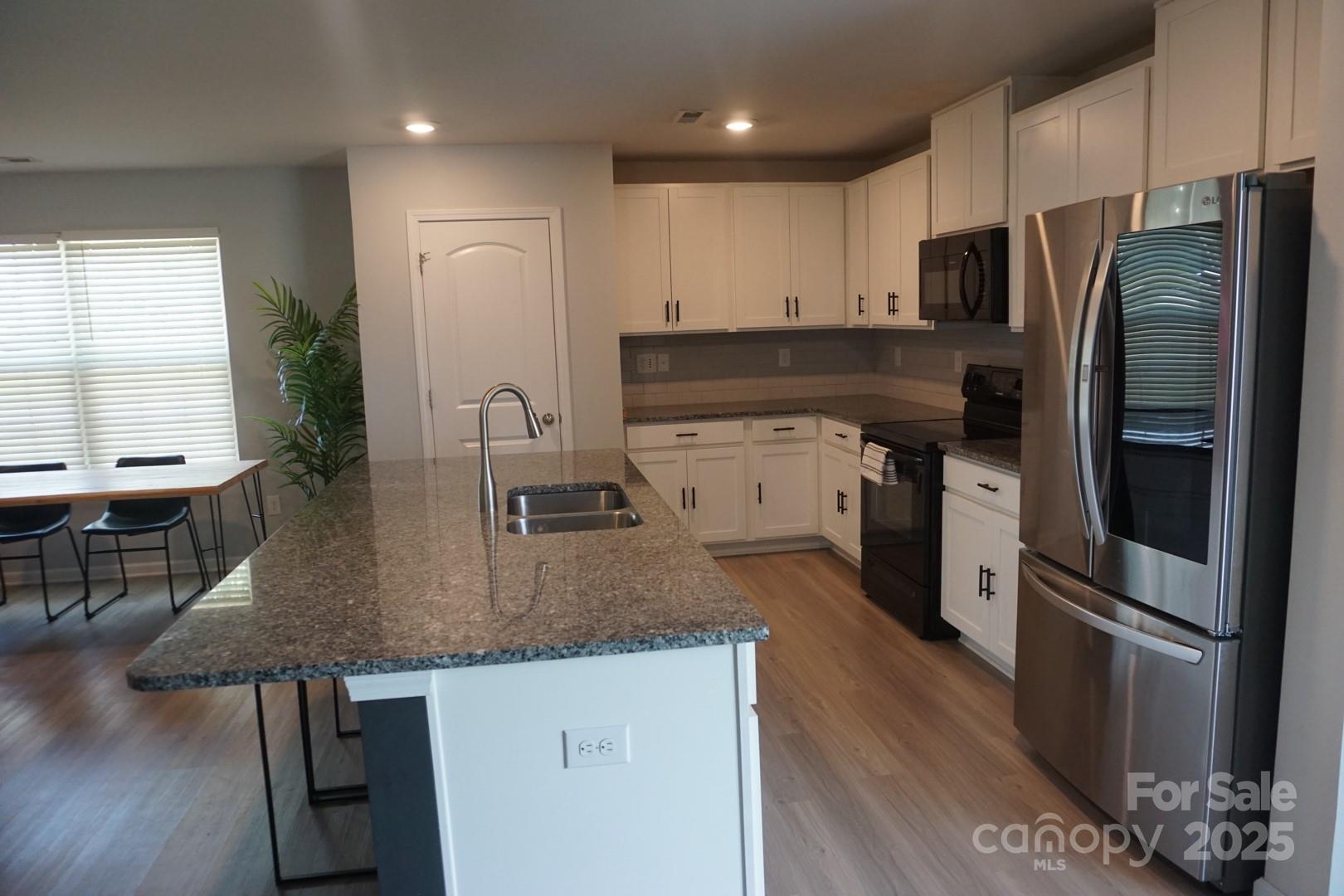 1276 Bryson Lane Denver, NC 28037 - Photo 5 of 16 a kitchen with stainless steel appliances granite countertop a sink stove and refrigerator
