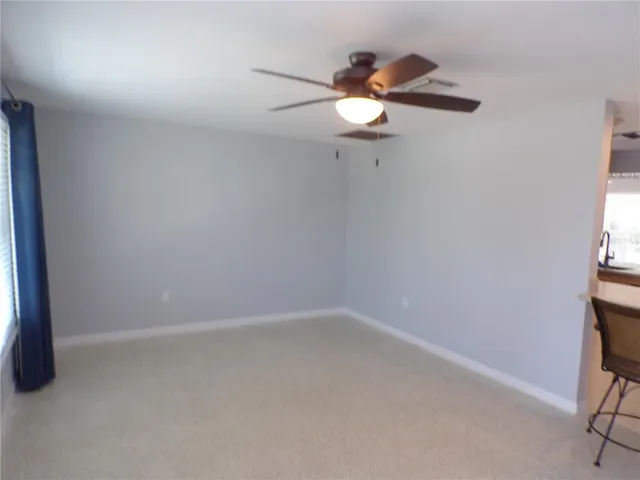 a view of a room with a stylish ceiling fan and entryway