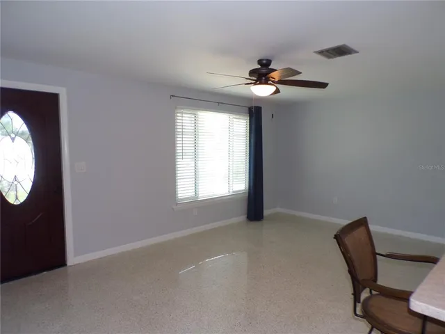 a view of a livingroom with a ceiling fan and window