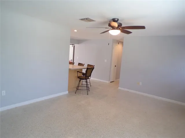 a view of a livingroom with furniture and chandelier fan