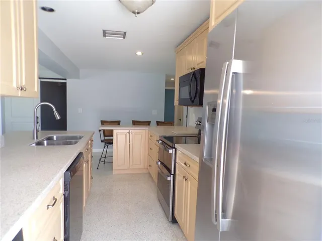 a kitchen with stainless steel appliances granite countertop a sink and dishwasher a stove top oven with white cabinets