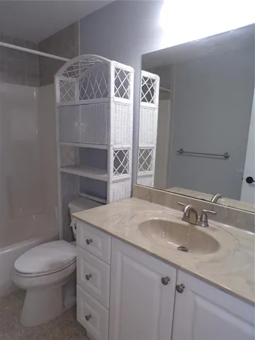 a bathroom with a granite countertop sink a toilet and shower