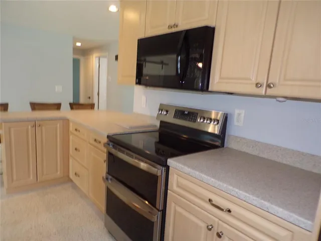 a kitchen with white cabinets and black appliances