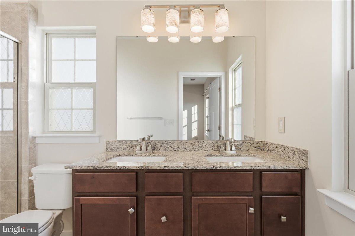 18060 Red Cedar Road Dumfries, VA 22026 - Photo 19 of 39 a bathroom with a granite countertop sink and a mirror