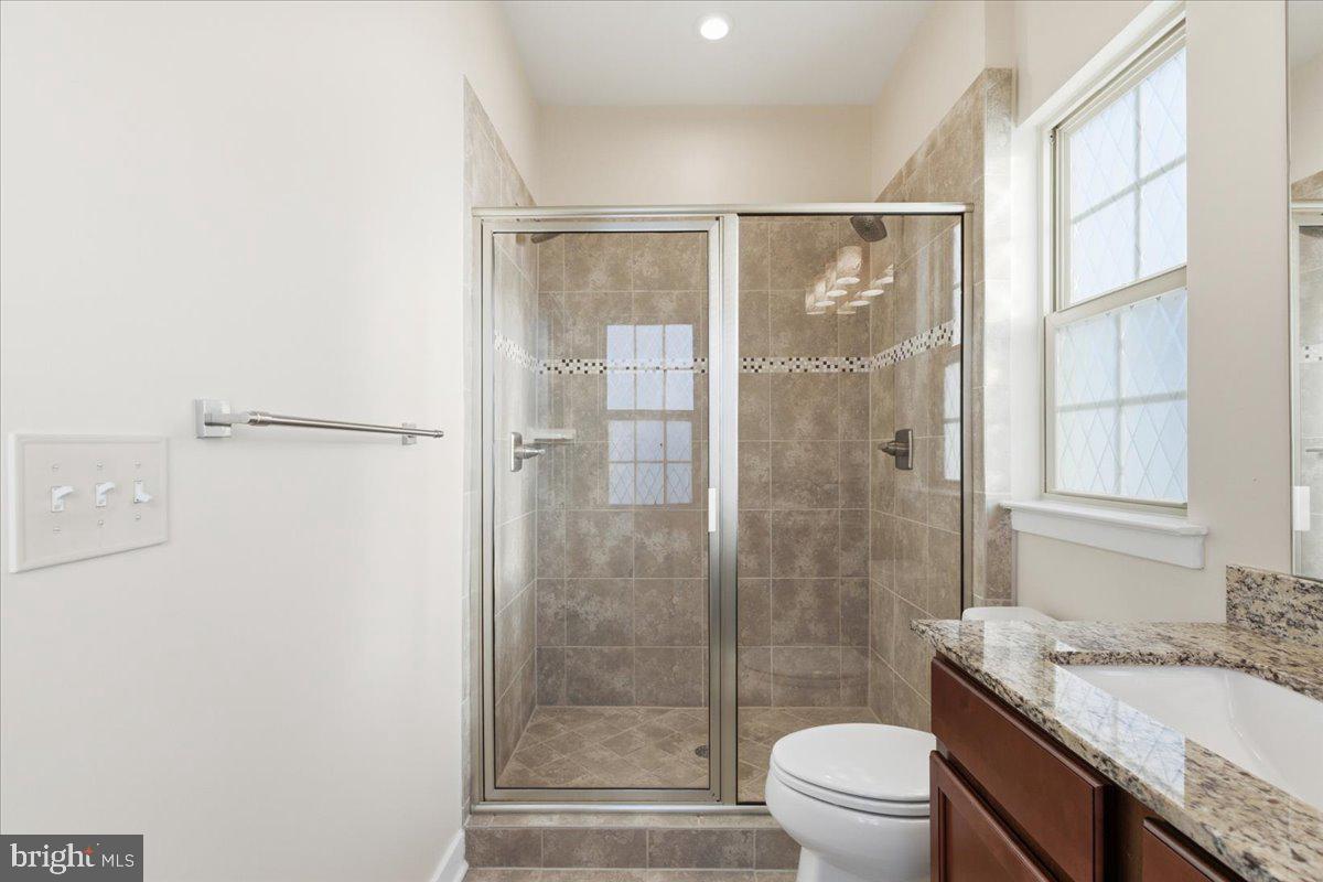 18060 Red Cedar Road Dumfries, VA 22026 - Photo 20 of 39 a bathroom with a granite countertop sink toilet and shower