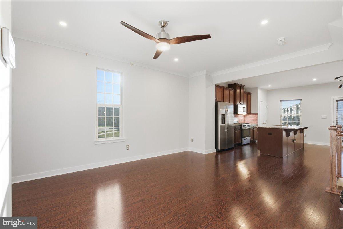 18060 Red Cedar Road Dumfries, VA 22026 - Photo 5 of 39 a view of empty room with wooden floor and a kitchen