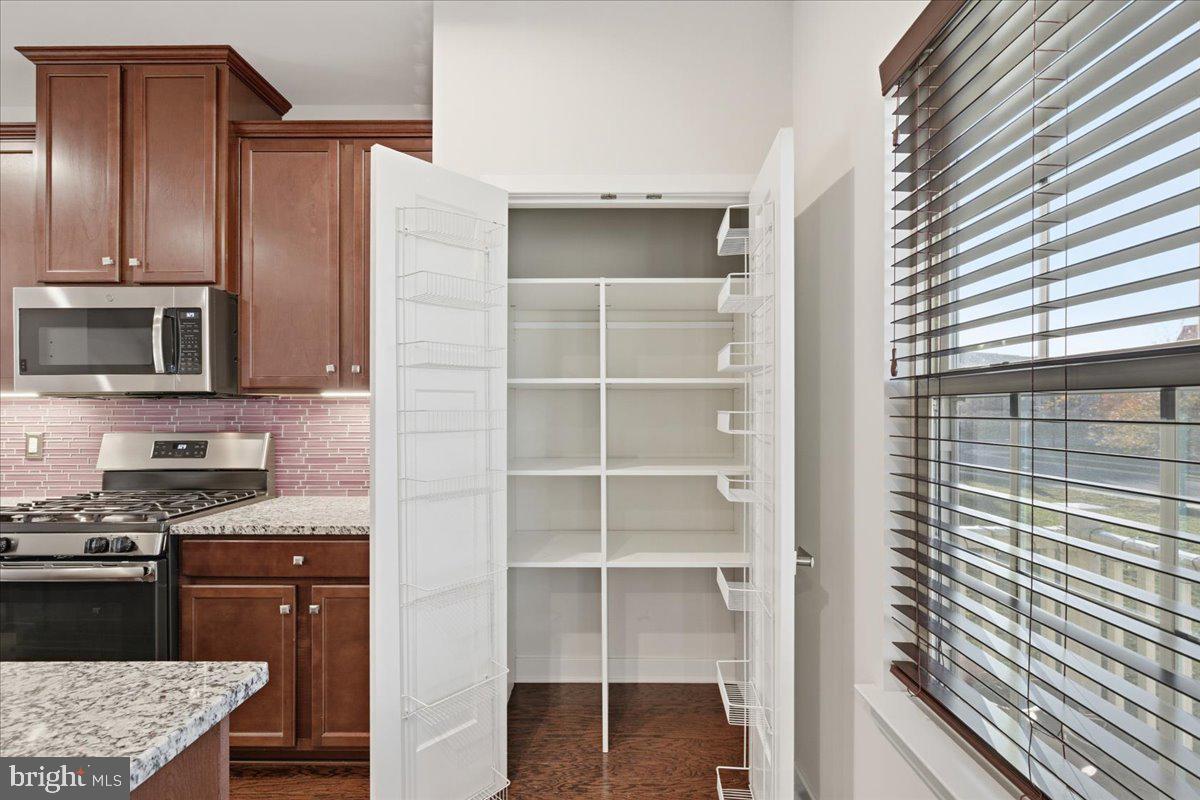 18060 Red Cedar Road Dumfries, VA 22026 - Photo 10 of 39 a kitchen with granite countertop a refrigerator and a stove top oven
