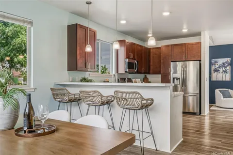 a kitchen with kitchen island granite countertop a sink cabinets and stainless steel appliances